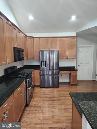 a kitchen with stainless steel appliances granite countertop a stove a refrigerator and a microwave
