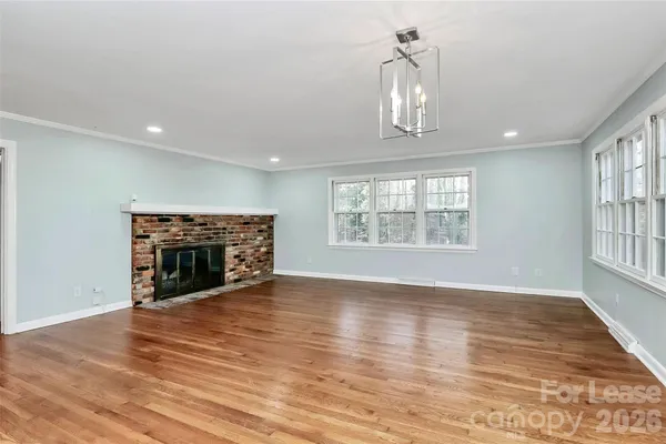 a view of kitchen with kitchen island wooden floor and fire place