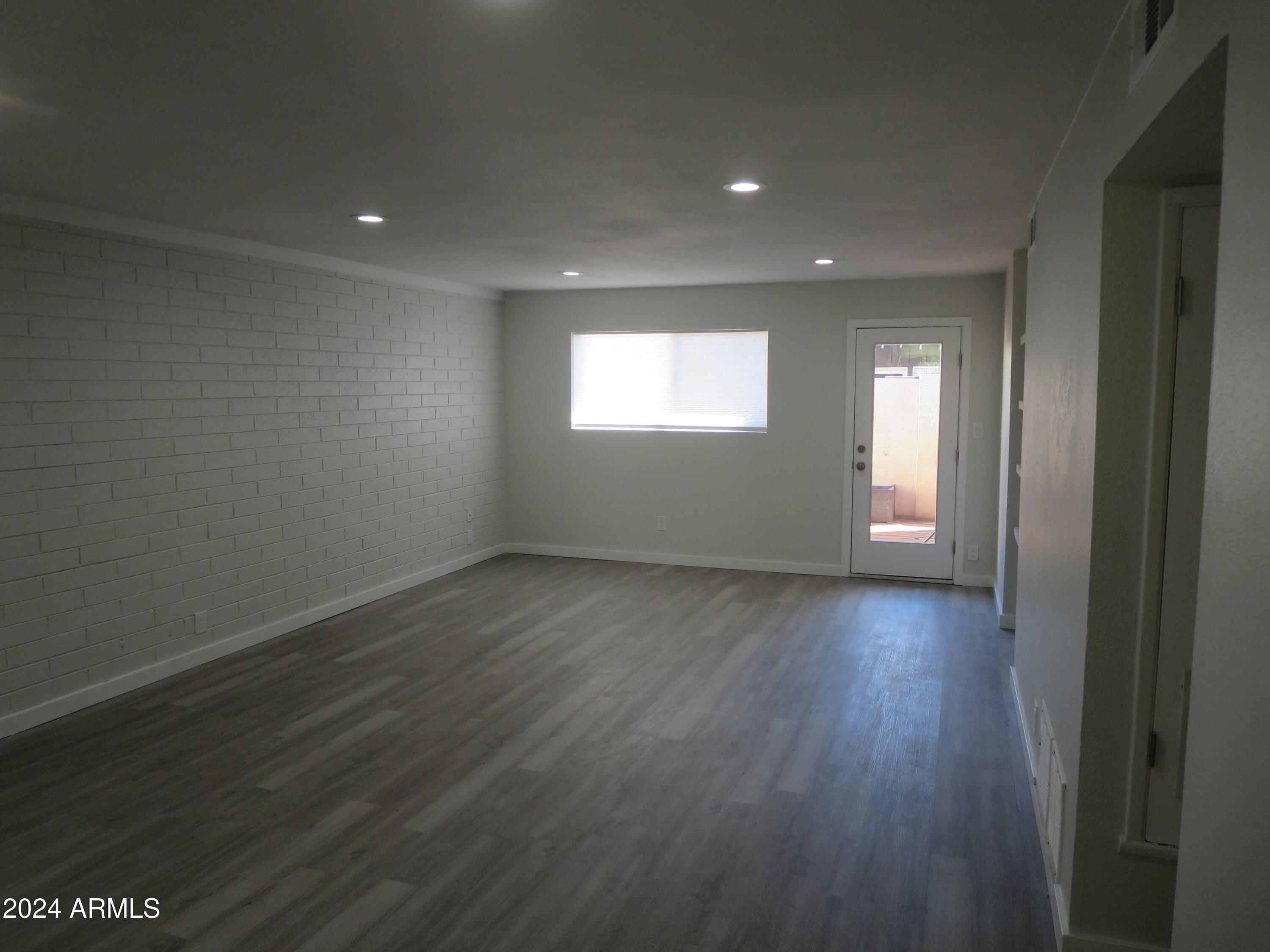 1450 East Bethany Home Road, Unit 34 Phoenix, AZ 85014 - Photo 11 of 15 an empty room with wooden floor and windows