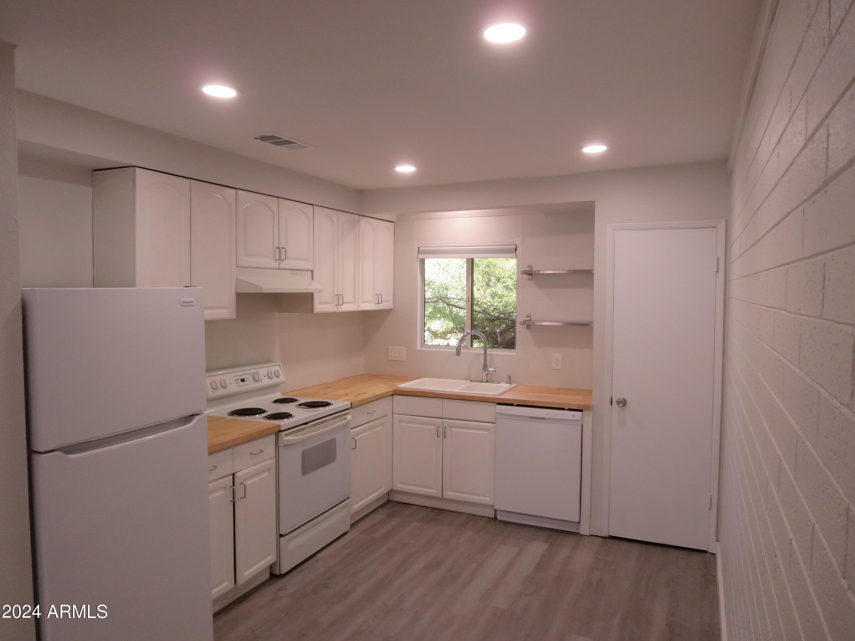 1450 East Bethany Home Road, Unit 34 Phoenix, AZ 85014 - Photo 3 of 15 a kitchen with a sink stainless steel appliances and cabinets