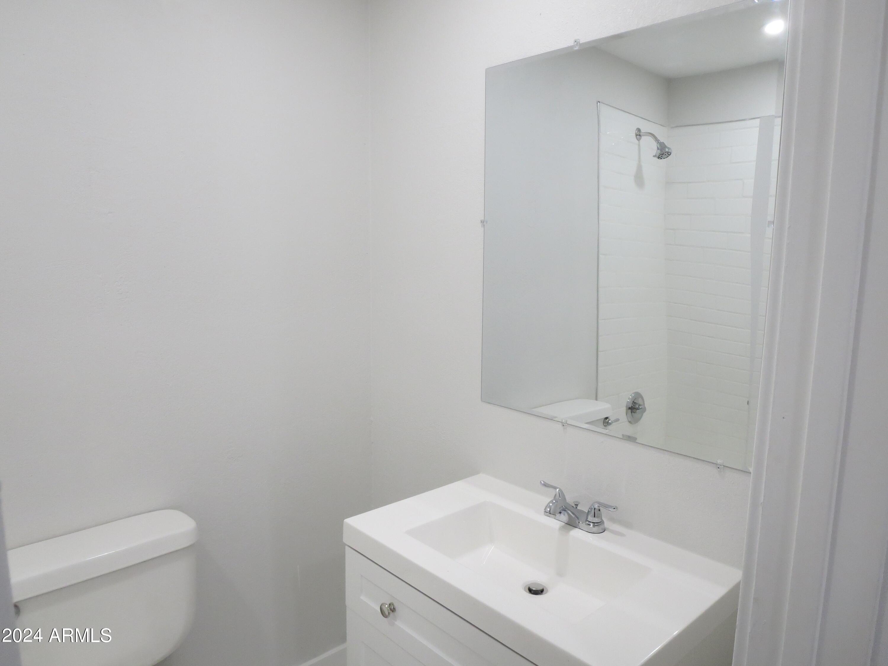 1450 East Bethany Home Road, Unit 34 Phoenix, AZ 85014 - Photo 6 of 15 a bathroom with a sink a toilet and shower