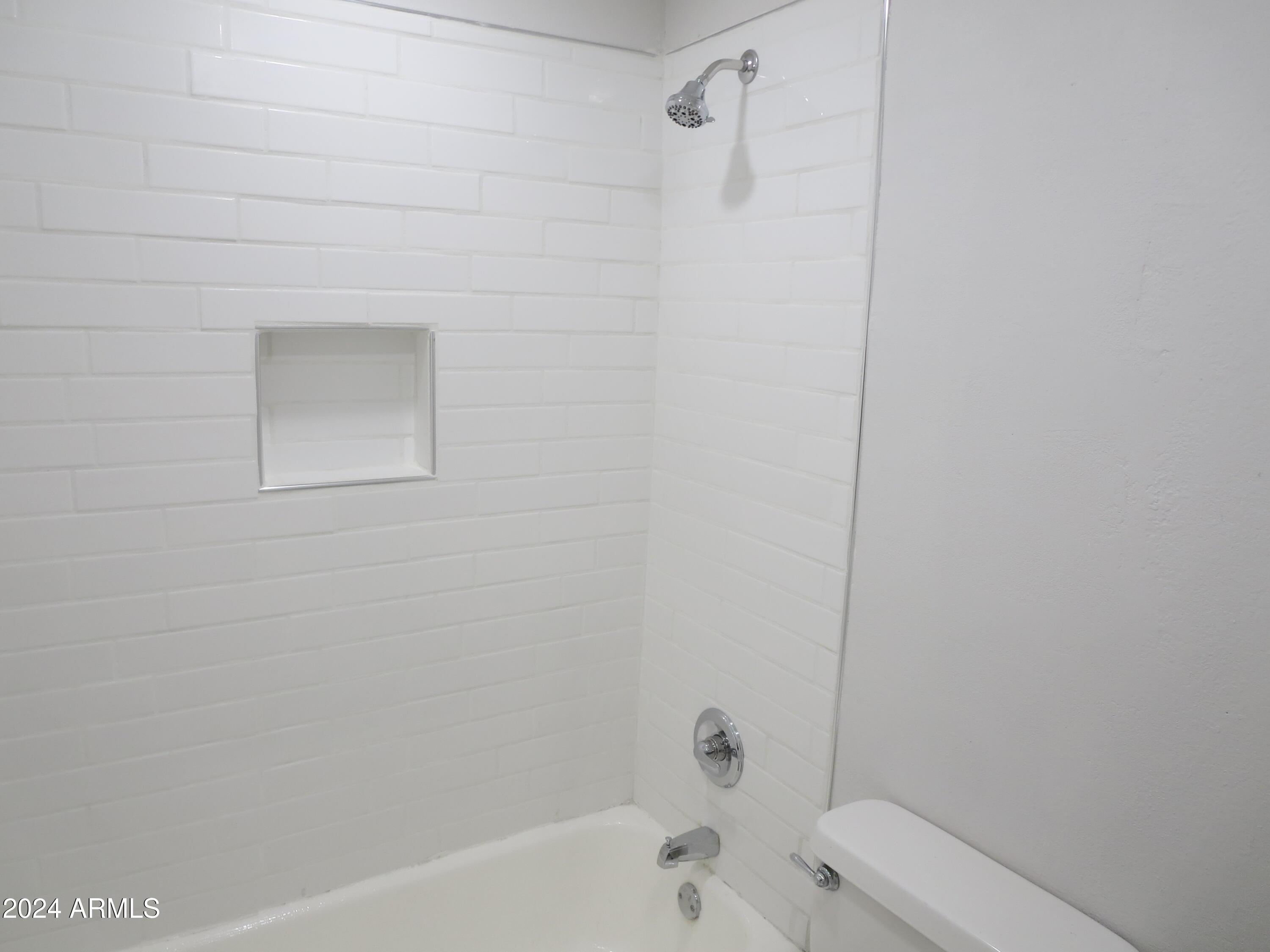 1450 East Bethany Home Road, Unit 34 Phoenix, AZ 85014 - Photo 7 of 15 a bathroom with a bathtub and toilet