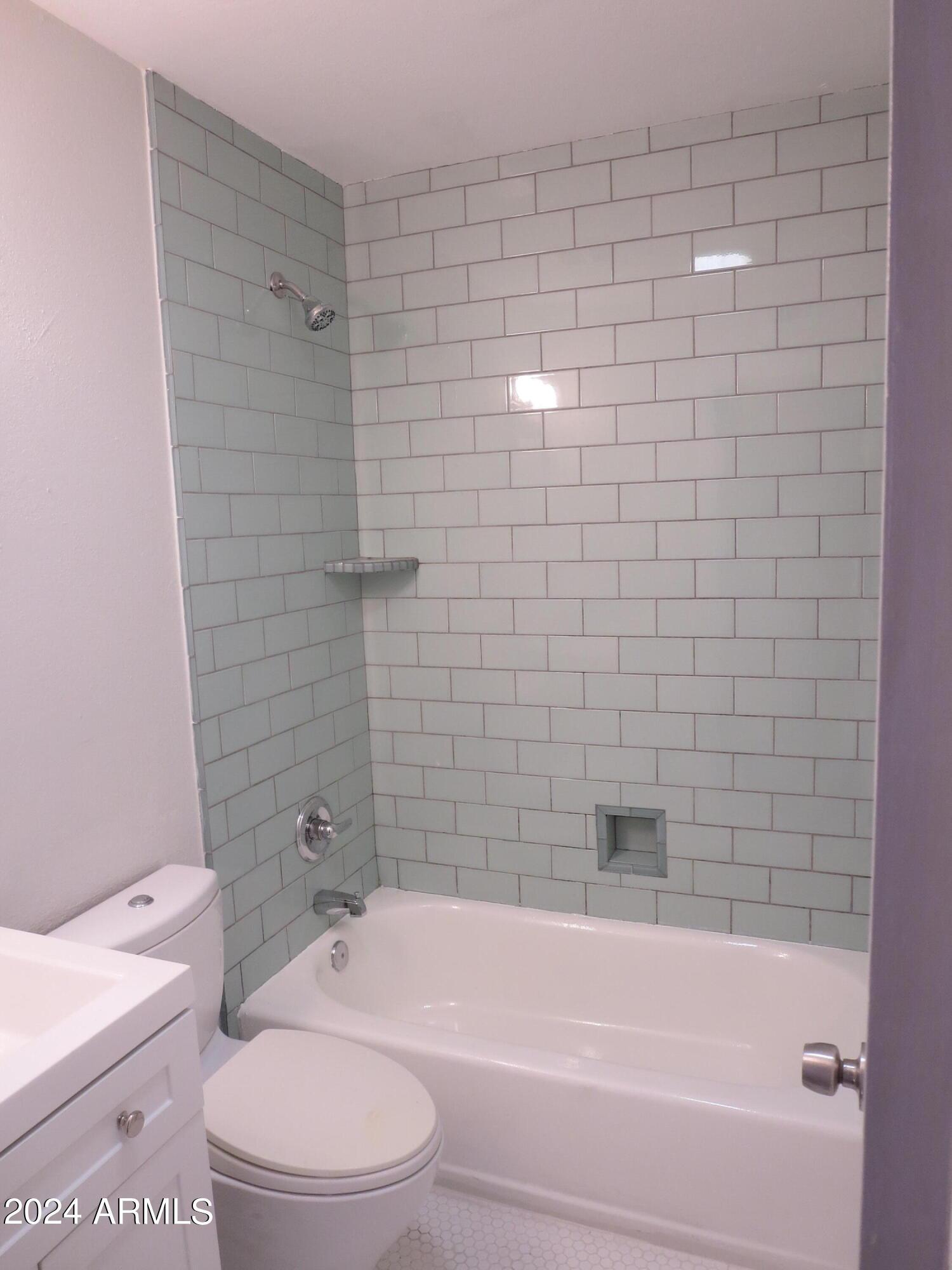 1450 East Bethany Home Road, Unit 34 Phoenix, AZ 85014 - Photo 9 of 15 a bathroom with a toilet and bathtub