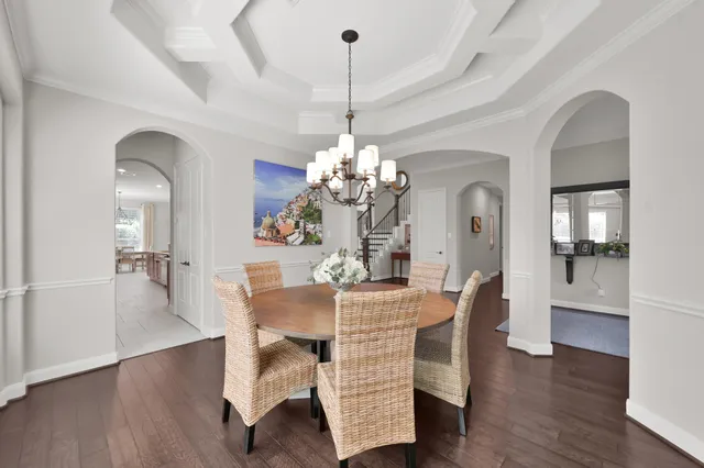 a dining room with furniture a chandelier and wooden floor