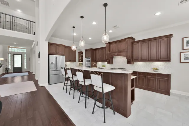 a kitchen with stainless steel appliances kitchen island granite countertop a kitchen island hardwood floor and a sink