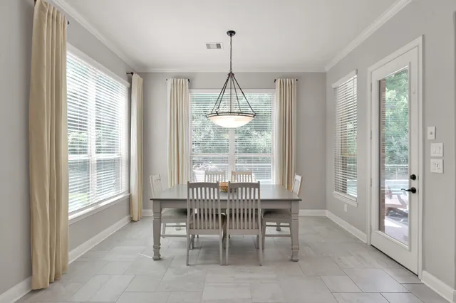 a dining room with furniture a chandelier and window