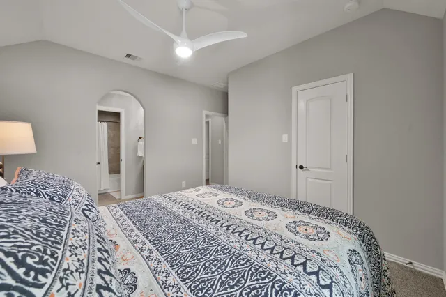 a spacious bedroom with a bed and a night stand