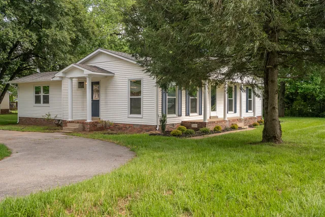 a front view of a house with a garden and yard