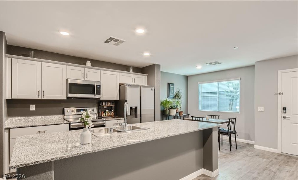 12110 Midnight Pine Road, Unit 3 Las Vegas, NV 89183 - Photo 4 of 13 Granite counters and stainless steel appliances adorn this bright, open-concept kitchen with a dining area.