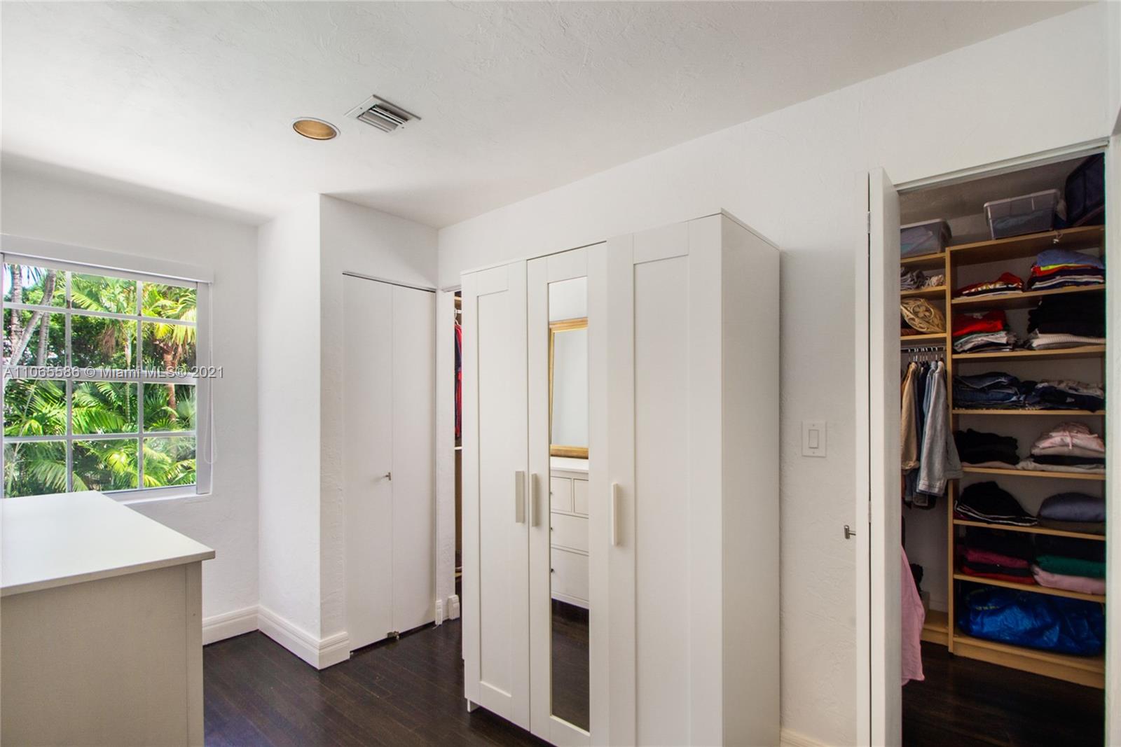 1701 Micanopy Avenue Miami, FL 33133 - Photo 16 of 40 a view of walk in closet with wooden floor and closet