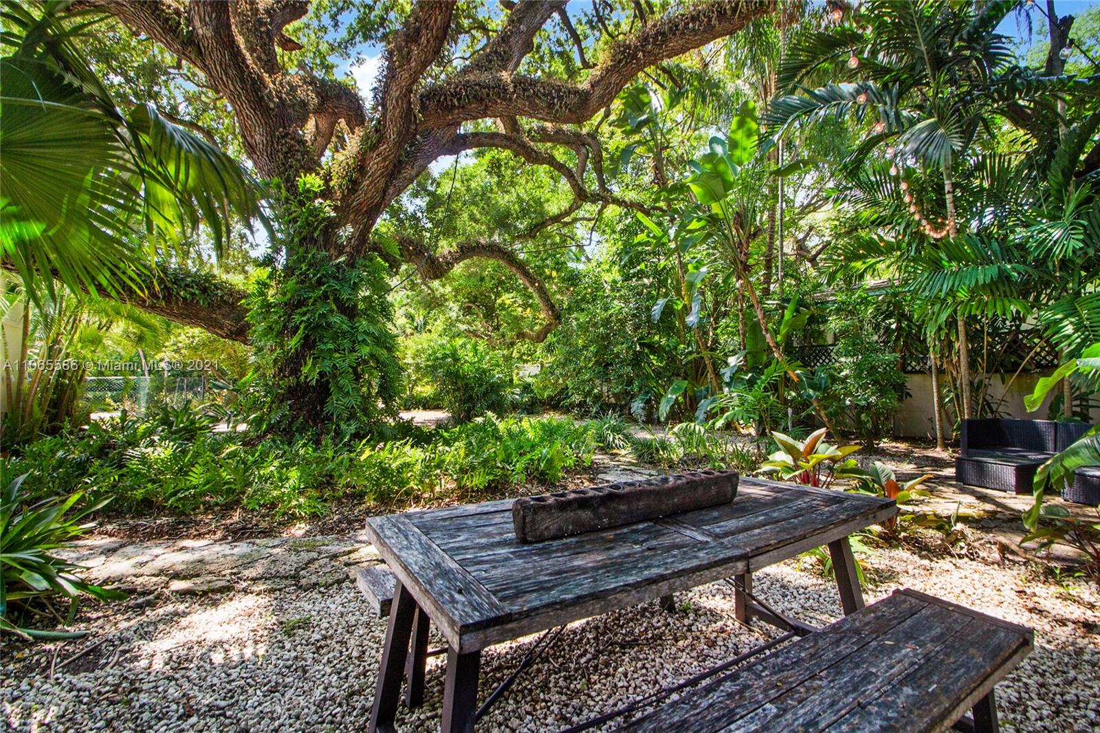 1701 Micanopy Avenue Miami, FL 33133 - Photo 37 of 40 a view of a wooden floor with a bench in a backyard