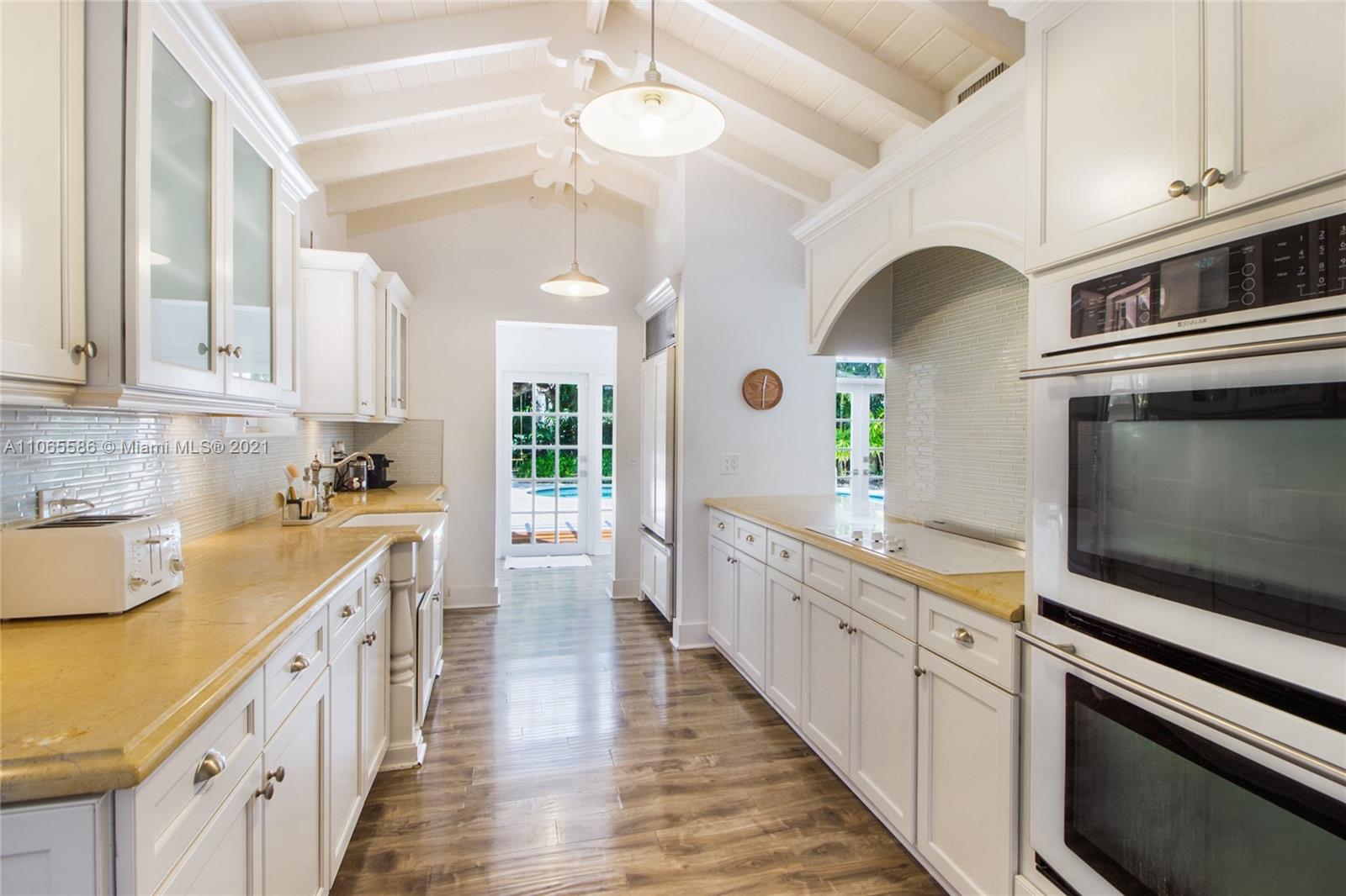 1701 Micanopy Avenue Miami, FL 33133 - Photo 10 of 40 a large kitchen with stainless steel appliances granite countertop a lot of counter space and wooden floors