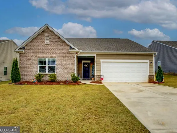 front view of a house with a yard and garage