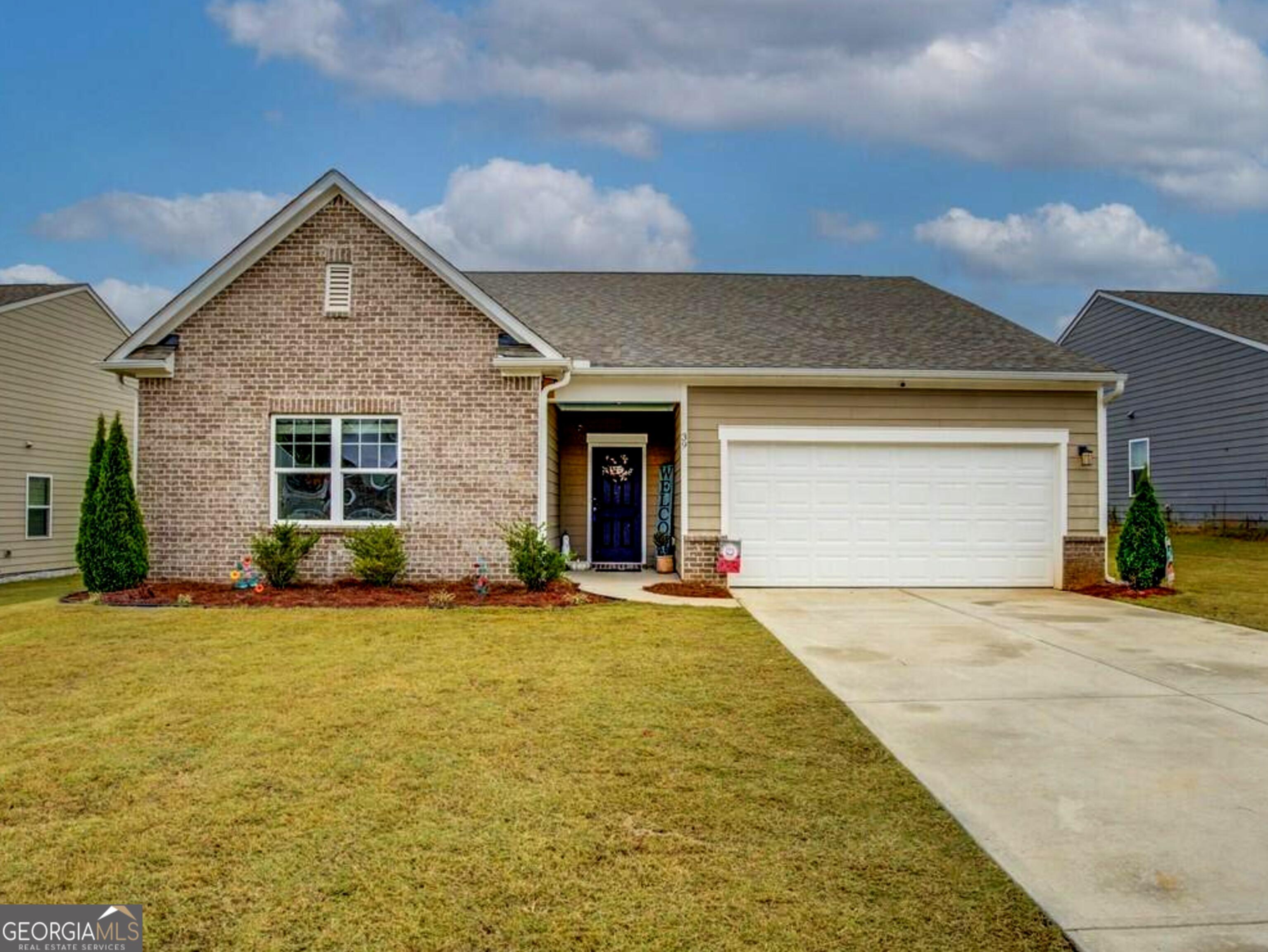 front view of a house with a yard and garage