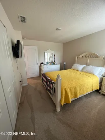 a bedroom with a bed and a view of kitchen