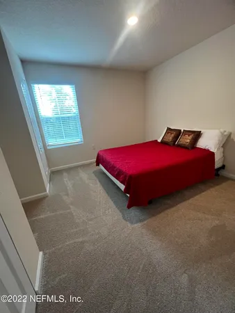 a spacious bedroom with a bed and a window