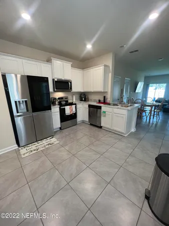 a living room with stainless steel appliances furniture and a flat screen tv