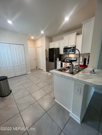 a kitchen with stainless steel appliances a sink a stove a microwave a sink a refrigerator and cabinets