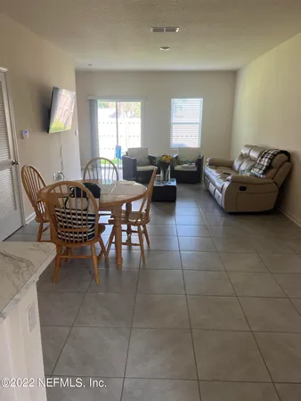 a living room with furniture a flat screen tv and a window