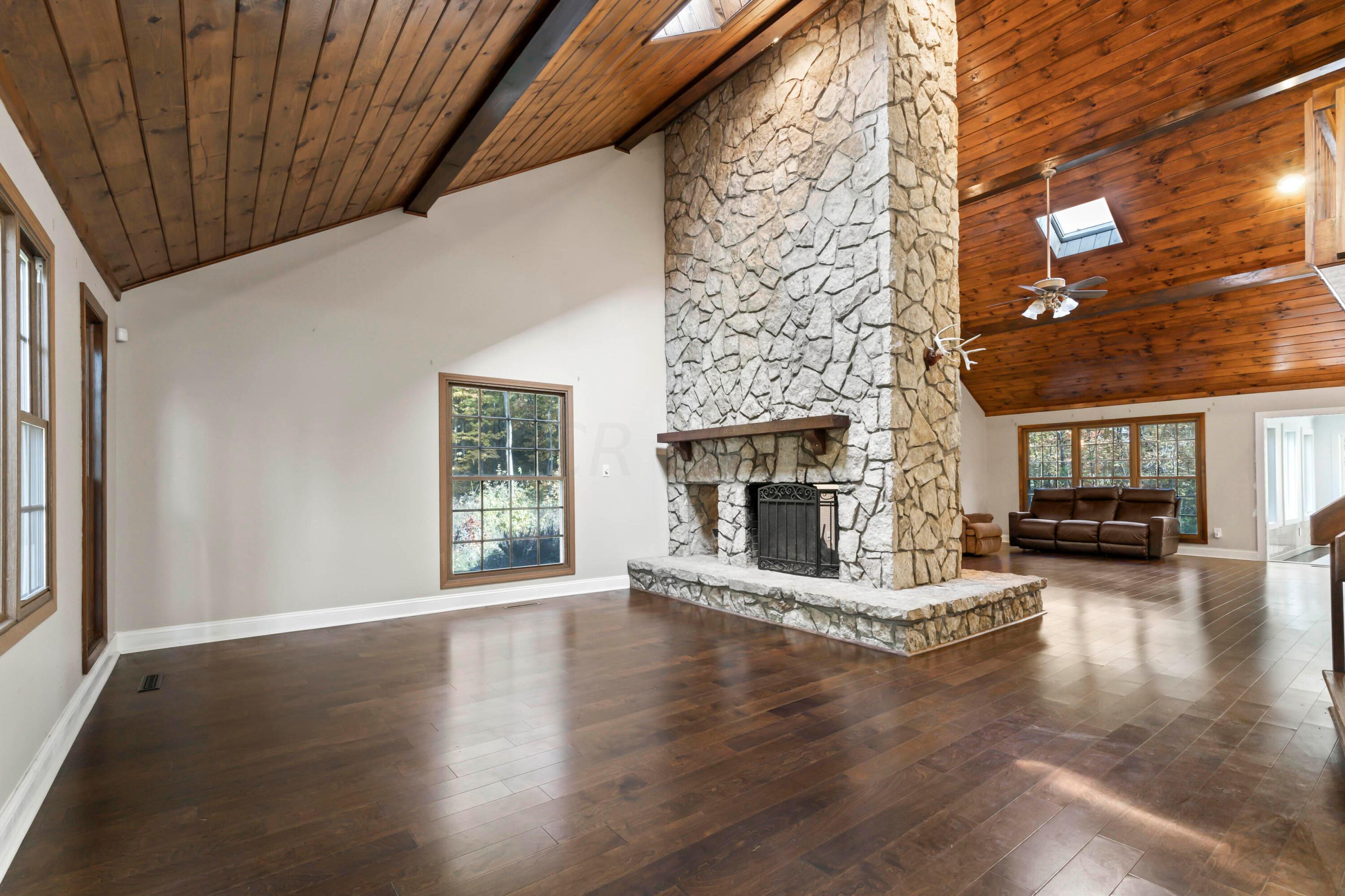 9495 Kilbourne Road Sunbury, OH 43074 - Photo 15 of 84 • New engineered hardwood
flooring May 2017
• Tan painted walls
• Wood paneled, vaulted ceiling
• Decorative ceiling beams
• Floor to ceiling, see-through
stone fireplace
• Skylight
• Can lighting
• Lighted ceiling fan
• Access to In-Law Suite/
Bonus Room