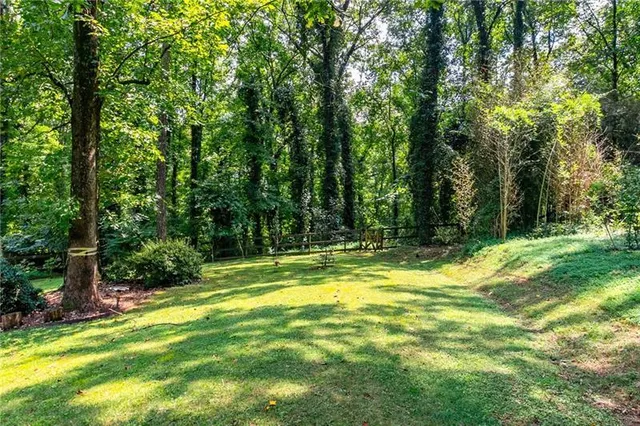 a view of a swimming pool with a big yard and large trees