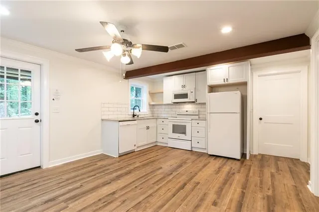 a kitchen with white cabinets and white appliances