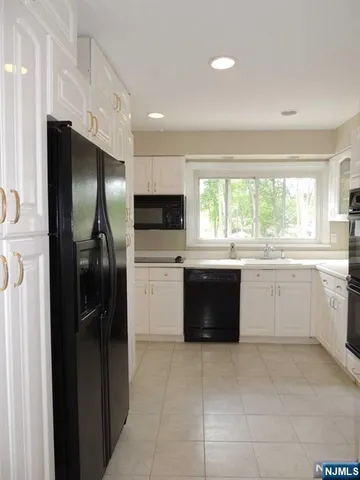 a large kitchen with a large window and stainless steel appliances