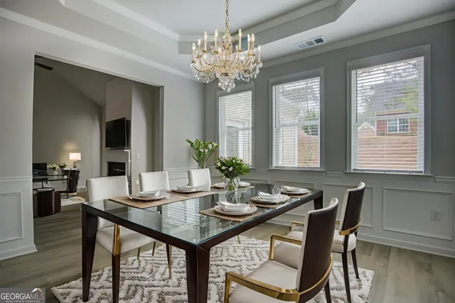 a dining room with furniture potted plants and wooden floor