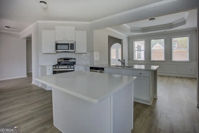 a kitchen with stainless steel appliances a sink a stove and a wooden floors
