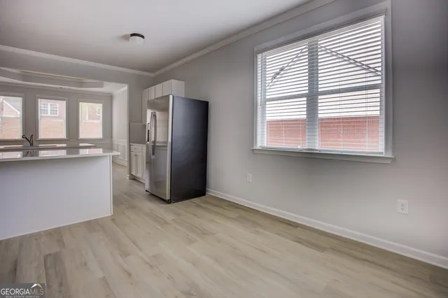 a view of a kitchen with wooden floor and a window