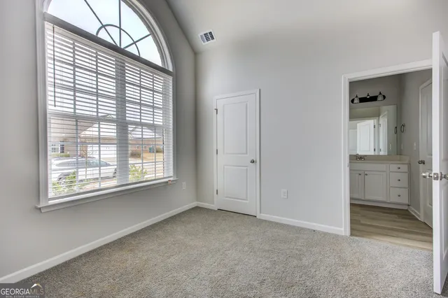 an empty room with a bathroom and a window