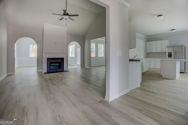 a view of empty room with wooden floor and fireplace
