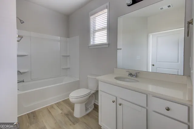 a bathroom with a sink toilet vanity granite tub and shower