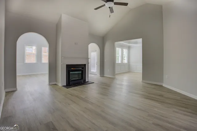 a view of a livingroom with wooden floor and a fireplace
