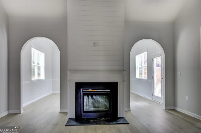 a living room with a fireplace and wooden floor