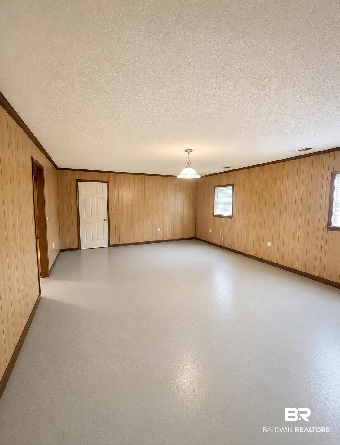 226 Elizabeth Street Evergreen, AL 36401 - Photo 29 of 35 Spacious room featuring light wood paneling, dark wood trim, and a semi-gloss light gray floor
