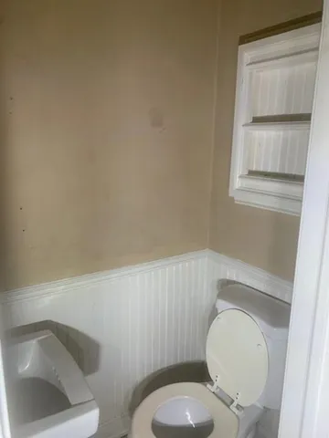 a white toilet sitting next to a bathroom sink and vanity