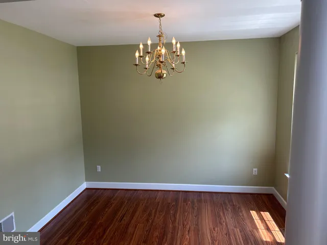 a view of a room with wooden floor and chandelier