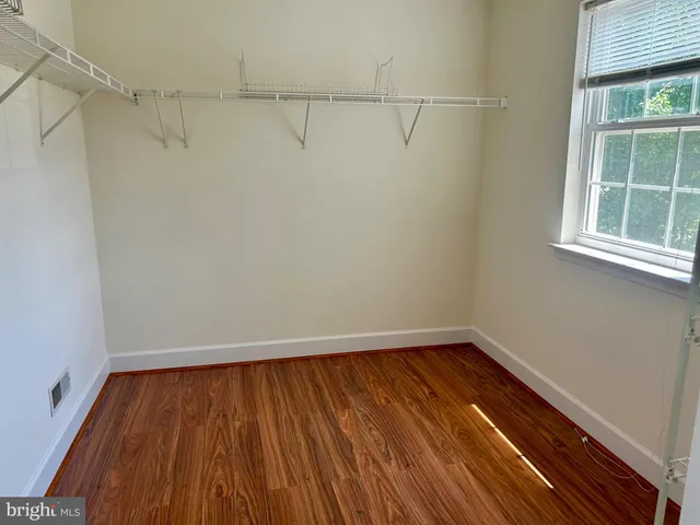 a view of a room with wooden floor and a window