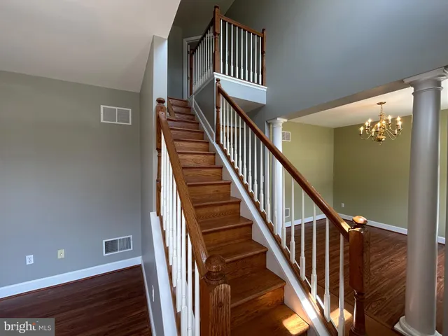 a view of staircase with railing and white walls