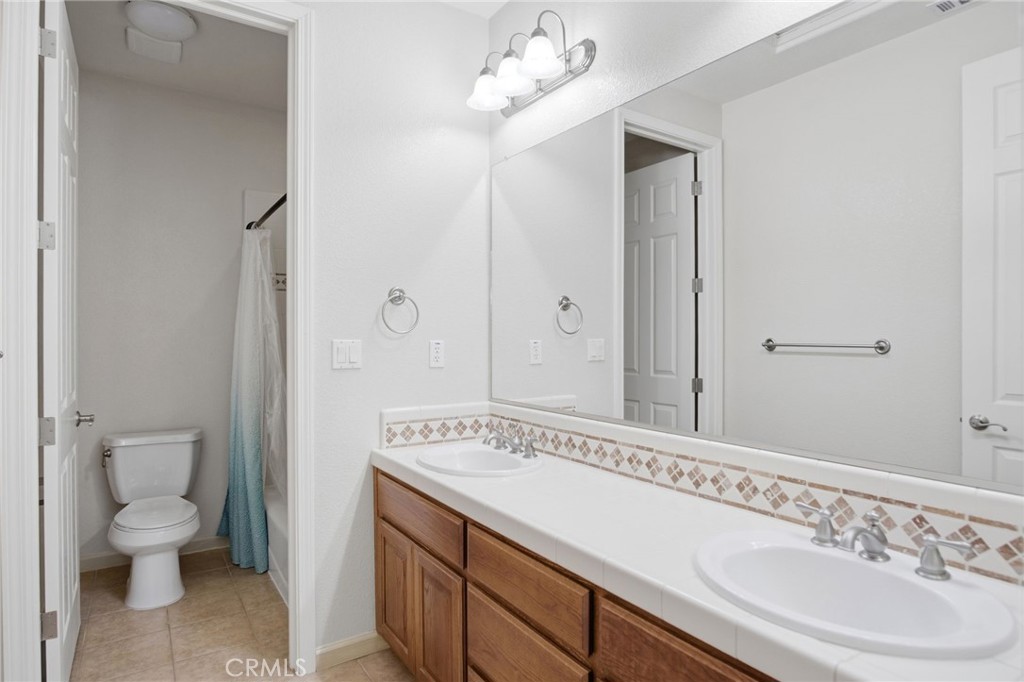 4822 Durant Way Merced, CA 95348 - Photo 24 of 48 a bathroom with a sink a toilet and a mirror