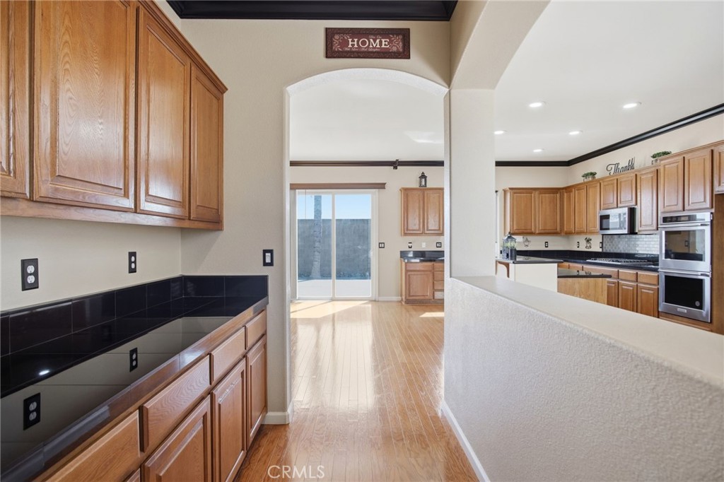 4822 Durant Way Merced, CA 95348 - Photo 9 of 48 a kitchen with stainless steel appliances granite countertop a refrigerator a sink dishwasher and white cabinets with wooden floor