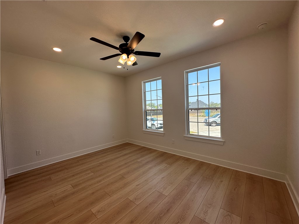 4302 Conestogo Court Bryan, TX 77802 - Photo 19 of 34 an empty room with wooden floor fan and windows