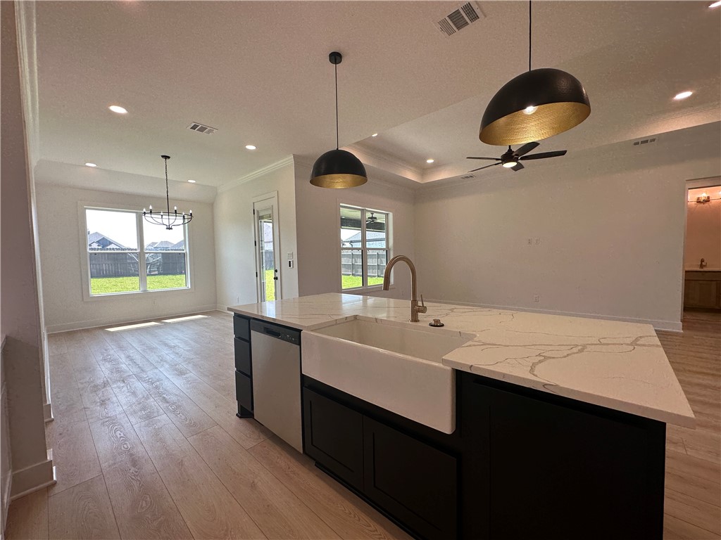 4302 Conestogo Court Bryan, TX 77802 - Photo 4 of 34 a kitchen with a sink chandelier and wooden floor