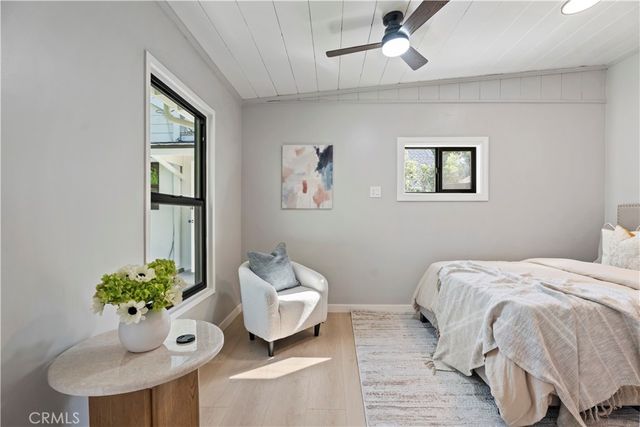 a view of a hallway with wooden floor and a bathroom