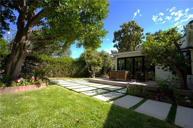 a view of a house with backyard and sitting area