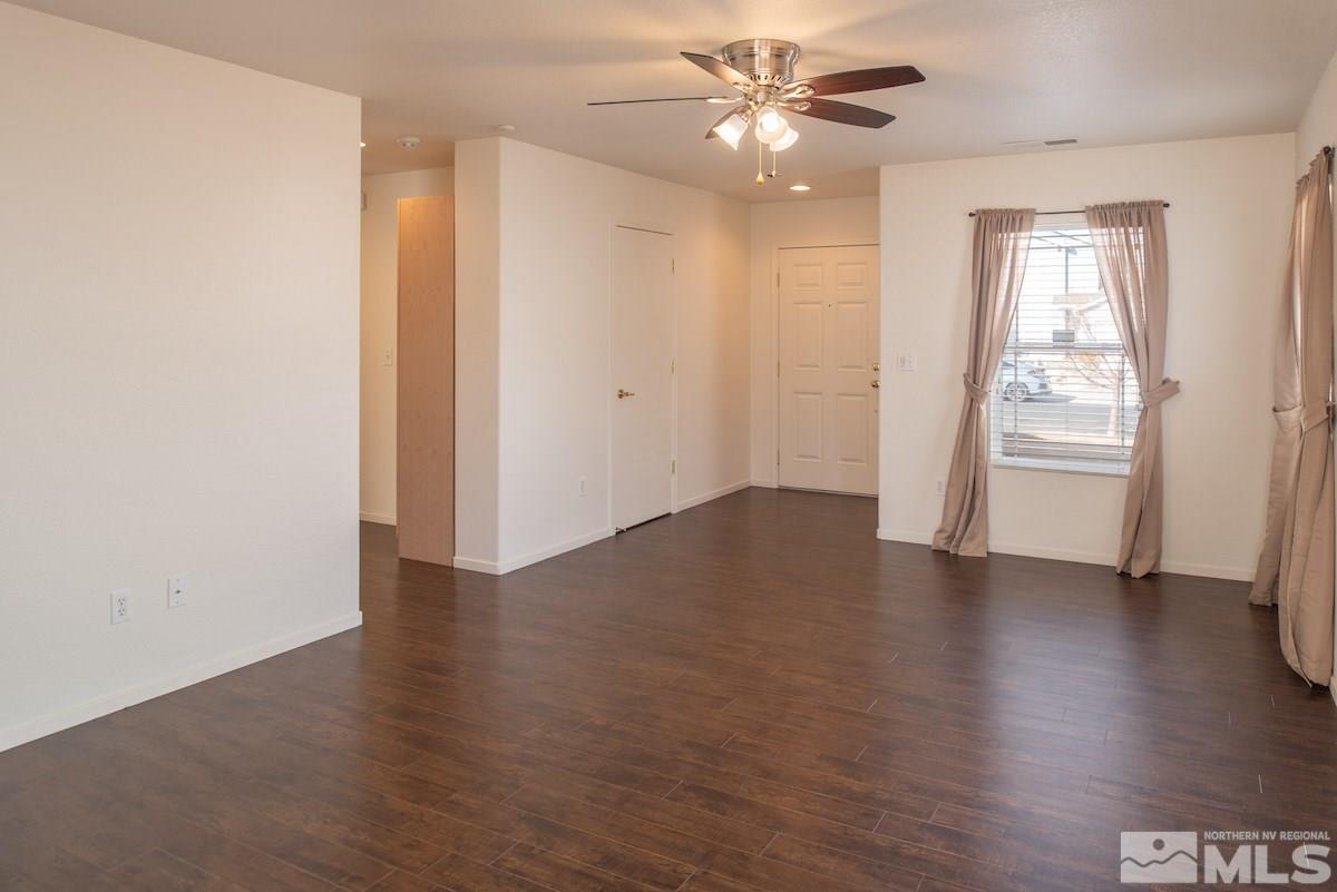 7764 Tulear Street Reno, NV 89506 - Photo 3 of 21 an empty room with wooden floor fan and windows
