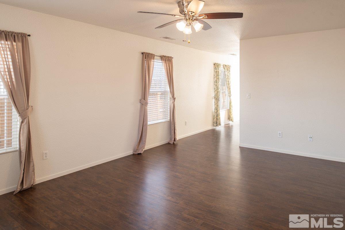 7764 Tulear Street Reno, NV 89506 - Photo 4 of 21 an empty room with wooden floor fan and windows