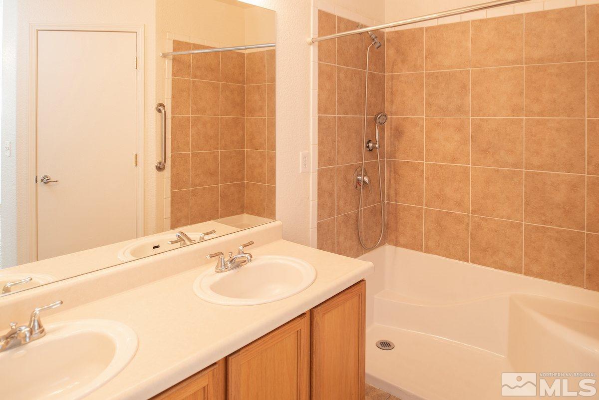 7764 Tulear Street Reno, NV 89506 - Photo 8 of 21 a bathroom with a sink shower and a mirror