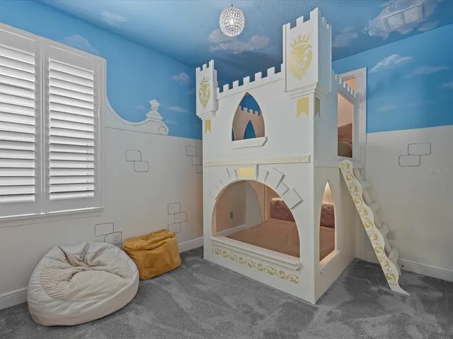 a bedroom with a bed and lamp on dresser